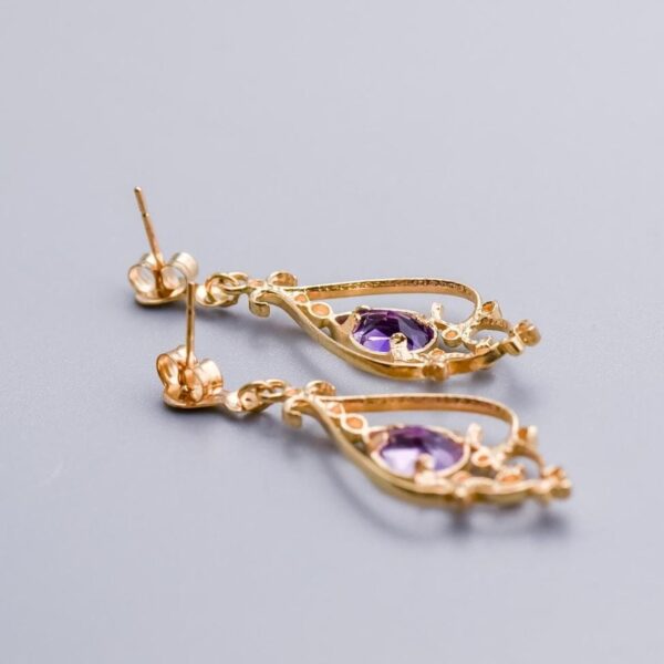Solid 9K Gold Amethyst Drop Earrings  This pair of 9K gold amethyst drop earrings features a pear-cut amethyst at its centre, elegantly set in a polished gold bezel.   Surrounding the gemstone is intr