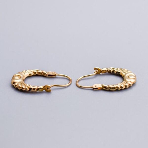Solid 9K Gold Creole Earrings  This pair of 9K gold creole earrings features a graceful oval design, adorned with intricate Bohemian-style patterns that add a touch of artistry and charm.   The earrin